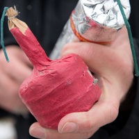Zwei Hände halten illegale, selbstgebaute Böller.