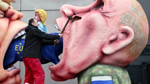 Jacques Tilly, Wagenbauer, schlägt mit einem Vorschlaghammer eine Putin-Figur auf einem seiner Mottowagen kaputt.