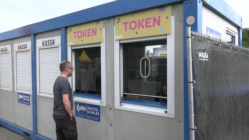 Eine Person steht vor Tokenstand