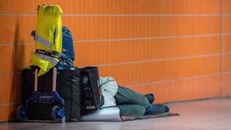 Eine wohnunglose Person schläft an einer U-Bahnstation