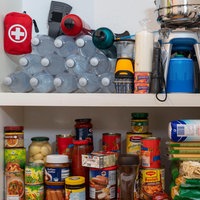Wasser, Gaskocher und Lebenmittelvorräte in einem Schrank