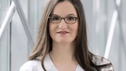 Eine Frau mit braunen Haaren und Brille