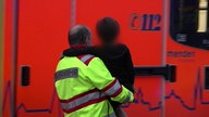 Ein Kind wird von einem Feuerwehrmann in Menden auf den Armen getragen