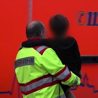 Ein Kind wird von einem Feuerwehrmann in Menden auf den Armen getragen