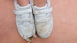 Füsse in ramponierten Sportschuhen 