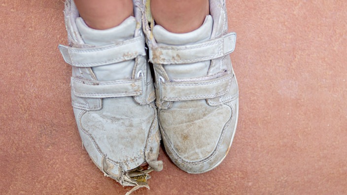 Füsse in ramponierten Sportschuhen 