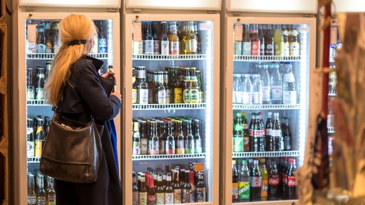 Eine Frau holt sich ein Getränk aus einem Kühlschrank im Kiosk Casablanca in Köln-Sülz