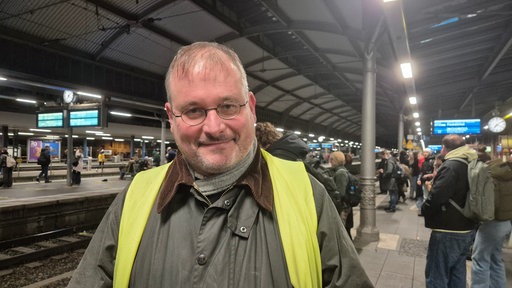 Ein Mann steht an einem Gleis des Bonner Hauptbahnhofs.