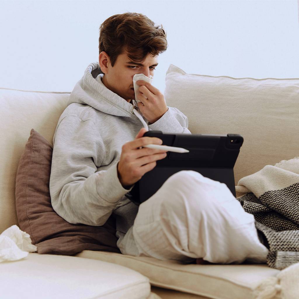 Kranke Person sitzt auf dem Sofa