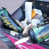 Lachgasbehälter in einem Mülleimer