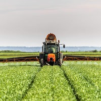 Ein Traktor verteilt Dünger auf einem Feld