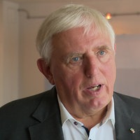  Karl-Josef Laumann spricht im WDR-Interview, im Hintergrund ist das Logo seines Ministeriums zu sehen