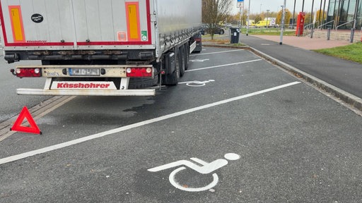 Ein LKW steht quer über Parkplätze für Menschen mit Behinderung