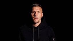 Lukas Podolski vor schwarzem Hintergrund