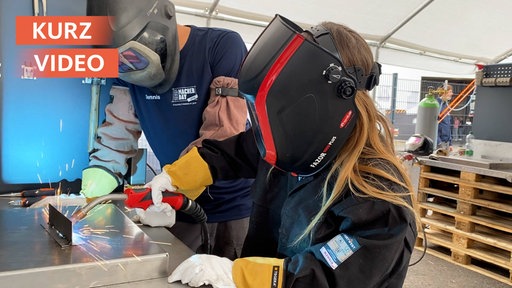 Kind und Mann schweißen gemeinsam mit Masken beim Handwerksfestival
