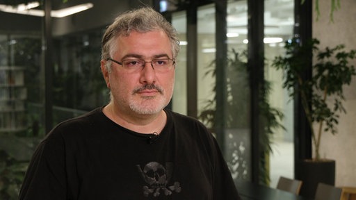 Ein Mann mit grauen Haaren und Brille