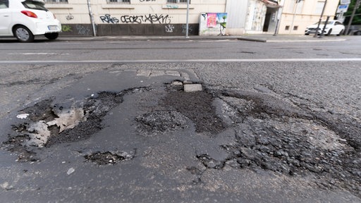  Eine marode Straße mit Schlagloch
