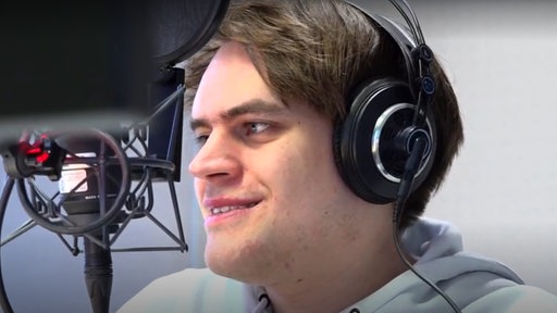 Matthias Blübaum vor einem Mikrofon des WDR