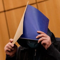 Der wegen schweren sexuellen Missbrauchs Angeklagte verdeckt sein Gesicht in einen Gerichtssaal im Landgericht