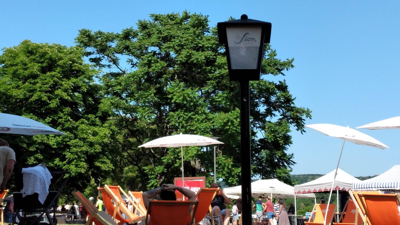 Beim Rheinauen-Flohmarkt in Bonn sieht man einen Mann, der sich an einem heißen, sonnigen Tag entspannt