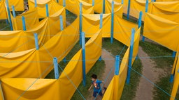 Ein Kind läuft durch das mobile Labyrinth an der Bonner Rheinaue. 