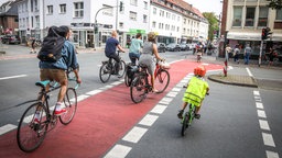 Fahrradfahrer überqueren eine Kreuzung auf einem Fahrradweg in Münster