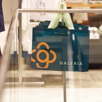 Taschen mit dem Firmen-Logo hängen in der neueröffneten Galeria-Filiale in Euskirchen für die Kunden bereit