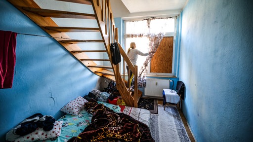Eine Frau steht in einem Zimmer ihrer Wohnung in einer Dortmunder Schrottimmobilie