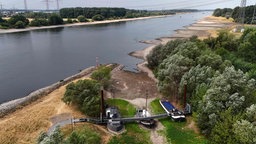Drei ehemalige Schiffe, die auf dem Trockenen stehen, verbunden durch eine Brücke, die jetzt als Café für Tagesausflügler dient.