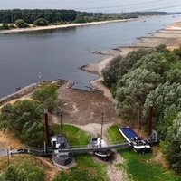 Drei ehemalige Schiffe, die auf dem Trockenen stehen, verbunden durch eine Brücke, die jetzt als Café für Tagesausflügler dient.