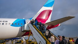 Urlauber steigen in ein Flugzeug ein 