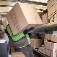  Ein Paketbote lädt Pakete in einen Transporter.