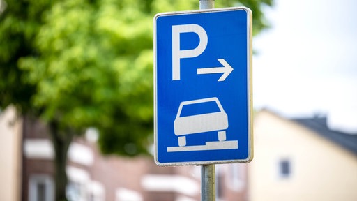 Ein Verkehrszeichen erlaubt das aufgesetzte Parken dem Gehweg.