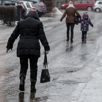 Passanten gehen vorsichtig auf einer vereisten Straße