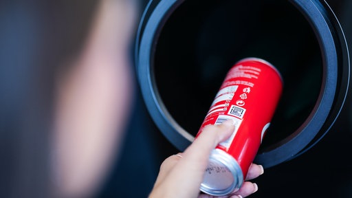 Eine Dose wird in einen Pfandautomat geschoben