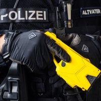 Ein Polizeibeamter hält einen Taser im Anschlag.