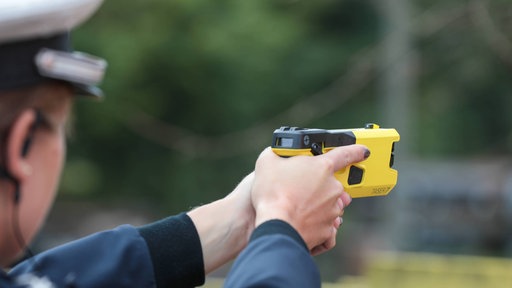 Eine Polizistin zielt mit einem neuen Taser.