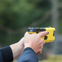 Eine Polizistin zielt mit einem neuen Taser.