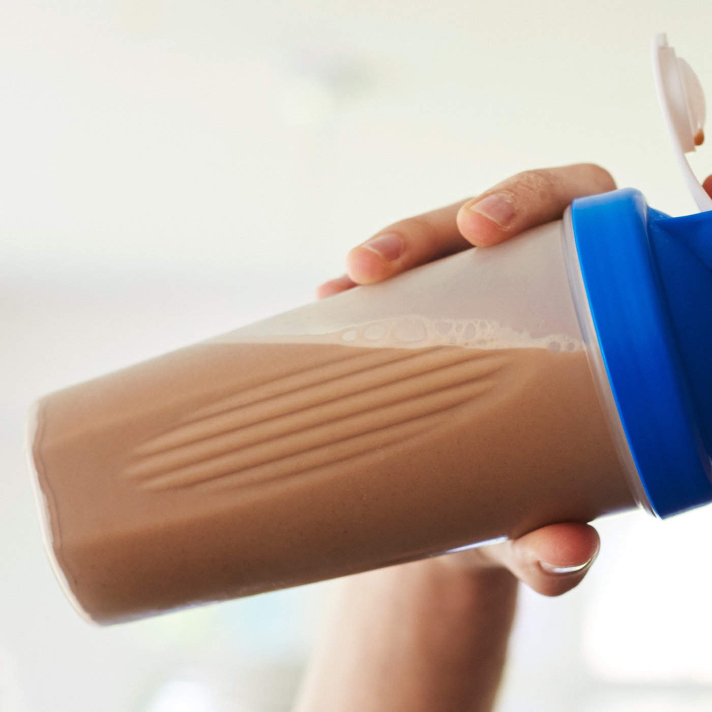 Ein junger Mann trinkt einen Proteinshake.