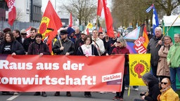 Personen mit Fahnen und Banner " Raus auf der Atomwirtschaft" in der Hand 