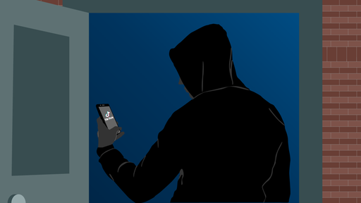 Eine Person, die einen Hoodie mit Kapuze trägt, schaut auf ihr Handy, auf dem die TikTok-App geöffnet ist