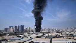 Eine schwarze Rauchfahne steigt aus einem Lagerhaus in Dubai.