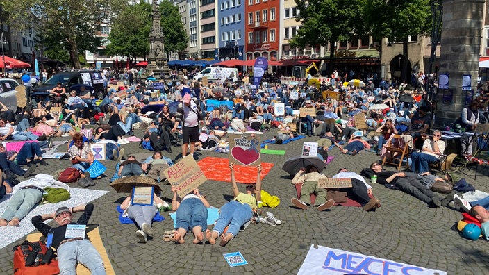 Menschen liegen auf einem öffentlichen Platz