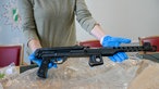 Eine Frau hält eine Schusswaffe in den Händen
