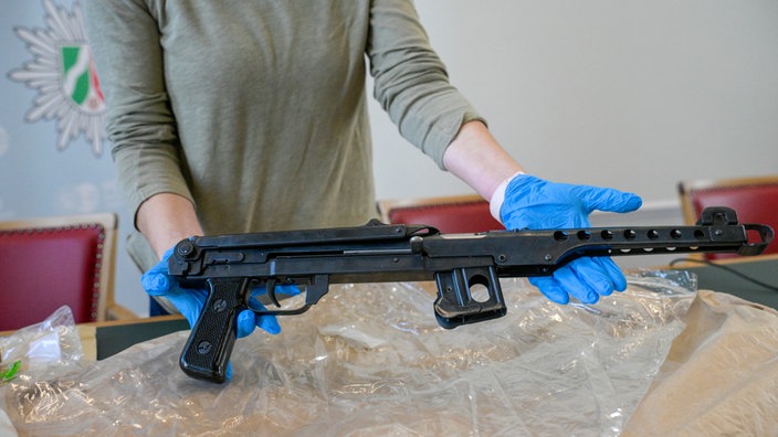 Eine Frau hält eine Schusswaffe in den Händen