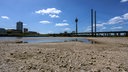 Rhein hat Niedrigwasser, große Flächen des Flusses liegen trocken, Blick auf die Rheinkniebrücke und den Rheinturm 