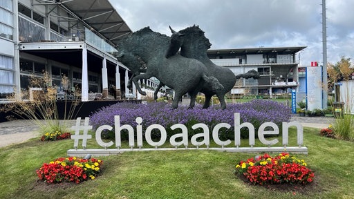 Eingang des CHIO Aachen mit einer Pferdeskulptur und dem Schriftzug #chioaachen