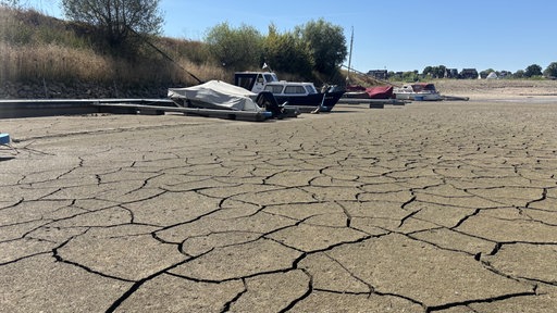 Einige Boote stehen auf dem trockenem Boden.