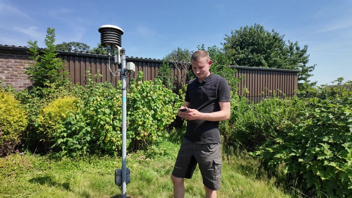 Landwirt Josef Joppen steht neben der Wetterstation auf seinem Grundstück.