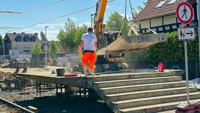 An der U-Bahn-Haltestelle Meerbusch-Hoterheide reißen Bauarbeiter mithilfe eines Baggers den Hochbahnsteig ab